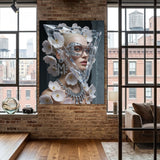 A large vertical wall art print depicting a stylized portrait of a woman with pink flowers and a geometric clear mask, displayed on a brick wall in a modern loft-style room with wood floors and windows.