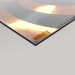 A close-up angled view of a 4mm glossy rectangular panel with a reflective metallic finish, showing warm copper-gold tones, dark grey bands, and a bright light reflection on a light grey background.