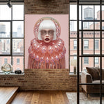 A large vertical wall art under acrylic glass featuring a stylized portrait of a woman with white hair and a pink bubble-like collar, displayed on a brick wall in a modern loft interior with windows and a sofa visible. 