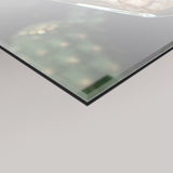 A close-up of a transparent 4mm glass panel shown at an angle against a light grey background.