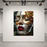 A large framed art print displayed on a large white gallery wall in a modern space. The artwork shows a close-up portrait of a woman's face wearing gold leaf eye patches, gold flower accent and silver diamond eyelashes, plus vivid red lips.