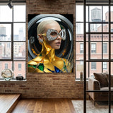 A large framed wall art featuring a stylized portrait of a woman wearing metallic gold and silver futuristic diamond eyewear, earrings and ear cuff. Her body is covered in gold with sapphires and emeralds accents. Scene is displayed on a brick wall in a modern loft interior with wood floors and large windows. 