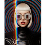 MizDragonfly Surreal Fine Art Optik Series portrait entitled Vortex featuring a futuristic blonde silhouette with a sharp bob haircut and red lips wearing oversized diamond-encrusted geometric sunglasses with tinted crystal lens against a hypnotic multi-colored concentric circle background.