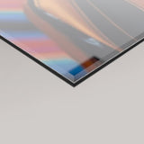 A close-up angled view of a 4mm glossy rectangular panel with a reflective metallic finish, showing the warmth of the Resonance artwork colours