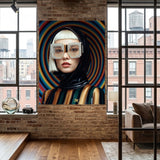 A large canvas wall art print featuring a stylized portrait of a beautiful asian woman, crystal-striped sunglasses, and a black, gold  and green striped hoodie, displayed on a brick wall in a modern loft room with wood floors and large windows.