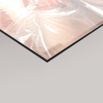 A close-up of a glossy transparent sheet or panel with a black edge, shown against a light gray background. 