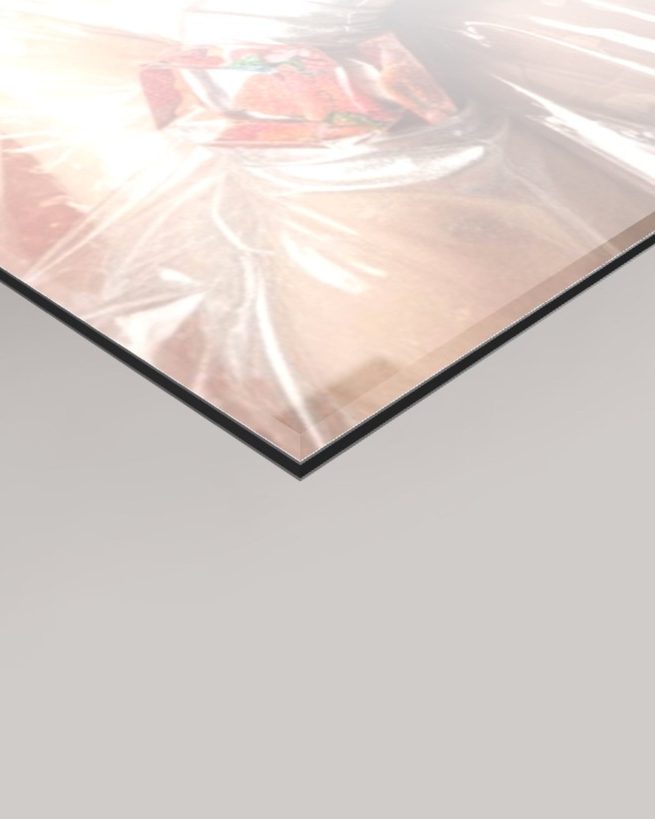 A close-up of a glossy transparent sheet or panel with a black edge, shown against a light gray background. 